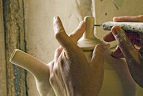 Patia Davis holding a pin about to cut to size a celery stick knob on a tea-pot lid